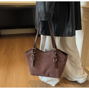 Dettaglio borsa tote in pelle scamosciata marrone scuro con fibbie argentate per uso quotidiano