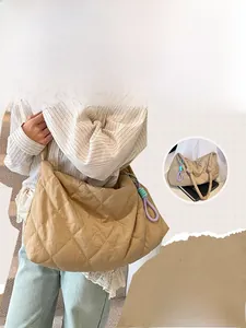 Close-up of quilted nylon crossbody bag featuring khaki diamond pattern and cord charm