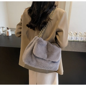Vue détaillée du sac à bandoulière en peluche grise avec chaîne sur le dos du mannequin
