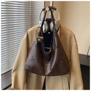 Détail du sac cabas marron foncé à fleurs ajourées avec son mini porte-monnaie assorti