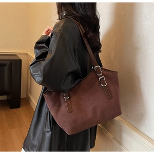 Dettaglio della borsa tote in pelle scamosciata marrone con fibbia in metallo argento