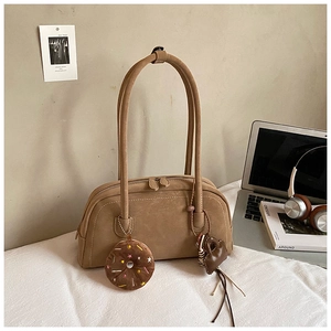 Detail view of brown suede baguette bag with cute doughnut and heart charms