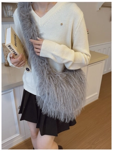 Détail d'un sac bandoulière en fausse fourrure grise avec texture pelucheuse et sangle large