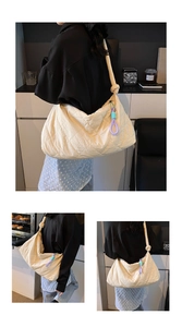 Close-up of cream quilted hobo bag with diamond stitching and decorative knot detail