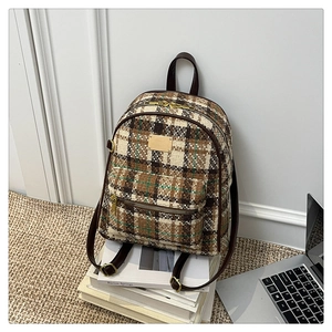 Détail du sac à dos vintage à carreaux en tweed avec des bretelles en similicuir marron