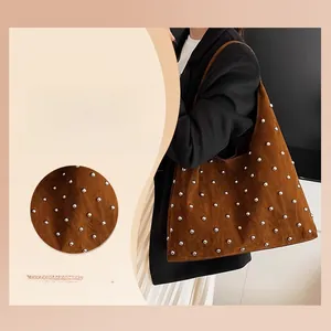 Close-up of brown suede hobo bag with silver rivet details and large capacity design