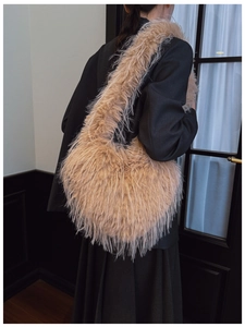 Détail du sac à bandoulière en fausse fourrure beige en forme de cœur avec texture douce