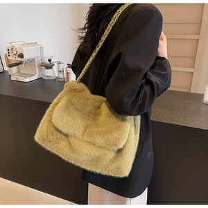 Détail du sac bandoulière en peluche vert olive avec texture luxueuse de chaîne dorée