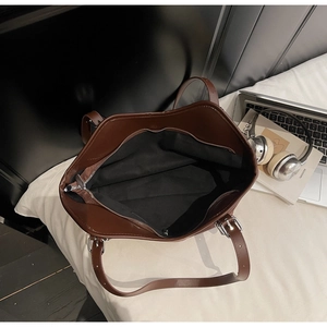 Vista macro dell'interno spazioso con tasca a zip di una borsa tote in marrone scuro