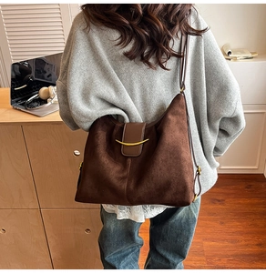 Detailed back view of a large brown suede hobo bag with gold crescent metal buckle