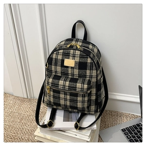Vue détaillée d'un sac à dos en tweed à carreaux avec fermetures dorées
