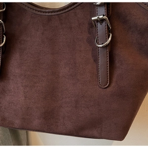 Primo piano dell'interno in pelle scamosciata marrone con bordi in pelle e fibbie argentate