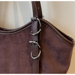 Dettaglio della borsa tote in pelle scamosciata marrone con fibbia in metallo argento