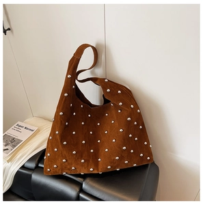 Detail of dark brown faux suede tote bag with silver metal studs and retro texture