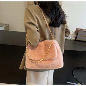 Détail d'un sac à bandoulière rose en fausse fourrure avec chaîne dorée élégante