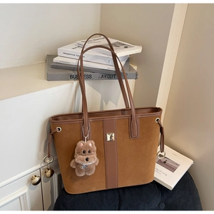 Brown suede tote bag with leather straps and a cute plush animal pendant on the side
