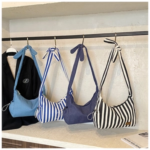 Détail de quatre sacs à bandoulière en toile rayée avec nœud décoratif sur la sangle
