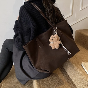 Deep brown oversized tote bag in matte finish with cute plush bear charm for daily commute