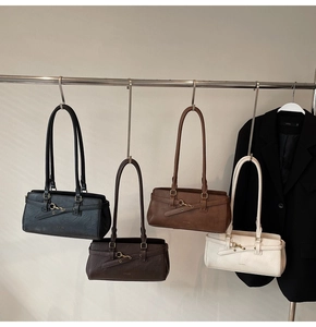 Detail view of four vintage leather underarm bags in various colors on a display rack
