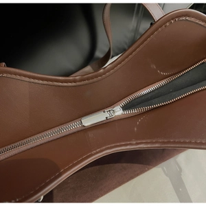 Dettaglio macro della zip in metallo e cuciture sulla borsa tote in pelle scamosciata