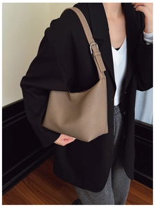 Detail view of brown lychee grain leather hobo bag with adjustable silver buckle strap