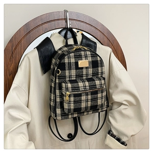 Détail du sac à dos vintage à carreaux noir et blanc avec ferrures dorées et cuir