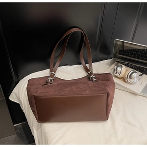 Dettaglio della borsa tote vintage in pelle scamosciata marrone con cinturini in pelle e oggetti