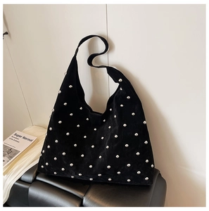 Detail of black suede hobo bag with silver round rivet studs and wide shoulder strap