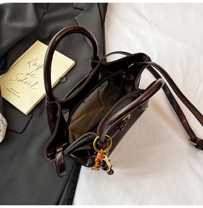 Top view of open retro dark brown tote bag with smooth texture and inner zipper pocket