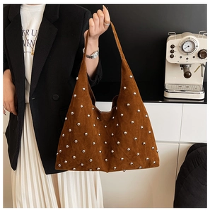 Detailed macro view of caramel suede texture and silver studs on the hobo handbag