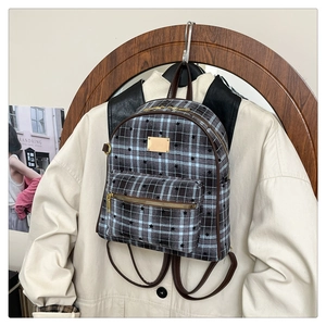 Détail d'un sac à dos vintage à carreaux avec étoiles et poche zippée dorée