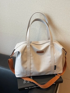 Minimalist beige canvas tote bag with orange woven handles and large storage capacity