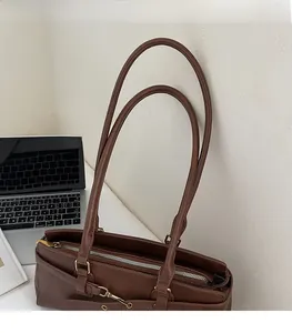 Detail of vintage brown leather tote bag showing slim shoulder straps and zip closure