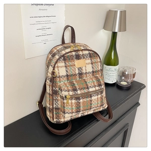 Gros plan détaillé d'un sac à dos vintage à carreaux avec tissu en tweed et lanières brunes