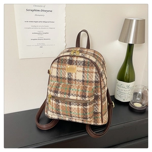 Détail du sac à dos en tweed à carreaux avec fermetures dorées et bretelles en cuir