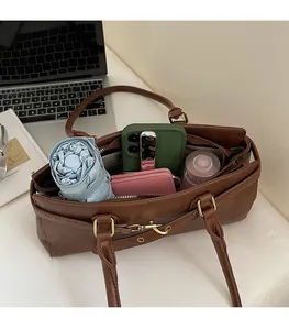 Spacious interior of brown leather shoulder bag showing ample capacity for daily essentials