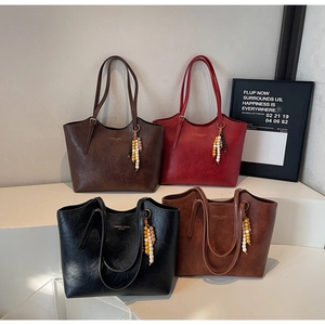 Dettaglio borse tote vintage in ecopelle in quattro colori con ciondoli bohémien