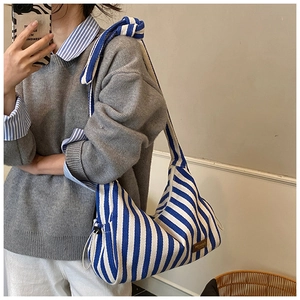 Détail du sac hobo en toile à rayures bleu et blanc avec large bandoulière nouée