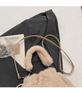 Détail montrant la texture en fausse fourrure et la bandoulière de ce sac seau abricot