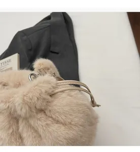 Détail du sac seau en peluche beige avec cordon de serrage et anneau métallique