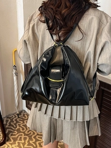 Vintage black patent leather shoulder bag with a unique triangular shape and gold buckle