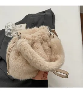 Détail du sac seau beige en fausse fourrure avec poignée et bandoulière en cuir réglable