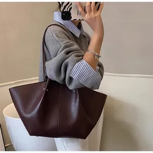 Detailed view of a retro burgundy tote bag showing polished leather texture and large capacity