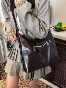 Vintage dark brown faux leather shoulder bag with gold clasp shown on a female model