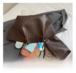 Detail view of spacious dark brown tote bag interior with inner pouch and office essentials