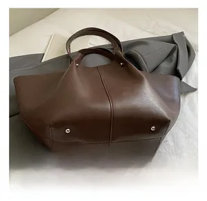 Detailed macro view showing the silver metal feet and bottom of the large brown tote bag