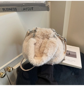 Gros plan sur la texture en fausse fourrure beige et les détails métalliques du sac
