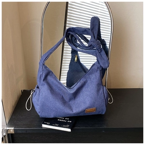 Gros plan du sac hobo en denim indigo avec bandoulière nouée et étiquette FFIMAO