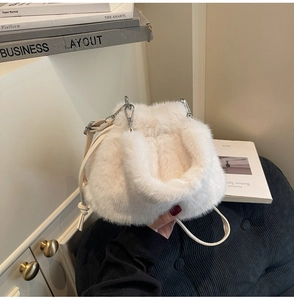 Détail d'un sac bandoulière en fausse fourrure blanche avec boucle en métal argenté