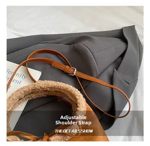 Detail of adjustable brown leather shoulder strap with silver buckle and fine edge finish